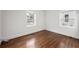 Clean bedroom with hardwood floors, white walls, base trim and two bright windows at 1612 Alder Se Ct, Atlanta, GA 30317