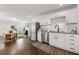 Well-lit kitchen with stainless steel appliances, granite countertops, white cabinets, and an open view to the living room at 1612 Alder Se Ct, Atlanta, GA 30317