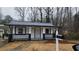 Street-level view of a cozy white home with a charming front porch and well-kept yard at 2322 Ewing Sw St, Atlanta, GA 30331