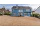 Exterior of blue house boasting a well-manicured lawn with a stone patio area and manicured hedges at 243 Wedmore Ct, Suwanee, GA 30024