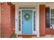 Close-up of a charming blue front door with white trim and a decorative wreath at 243 Wedmore Ct, Suwanee, GA 30024