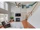 Inviting living room featuring a fireplace, large windows, and a stylish ceiling fan at 243 Wedmore Ct, Suwanee, GA 30024