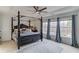 This main bedroom is a spacious retreat with a luxurious four-poster bed and ample natural light at 243 Wedmore Ct, Suwanee, GA 30024