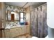 Bathroom with mirror and window above sink, plus patterned shower curtain at 559 Quail Trail Rd, Auburn, GA 30011