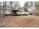 Exterior view of mobile home surrounded by woods and leaves at 559 Quail Trail Rd, Auburn, GA 30011