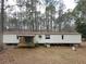 Exterior of home with a partially covered porch and wooded landscape at 559 Quail Trail Rd, Auburn, GA 30011