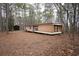 Home exterior in wooded setting with storage shed at 559 Quail Trail Rd, Auburn, GA 30011