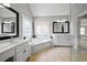 Bathroom featuring double vanity, soaking tub under a stained glass window, tile floors, and glass shower at 1677 Angelica Ct, Lawrenceville, GA 30043