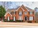 Stately brick home featuring manicured landscaping, black shutters, and a welcoming front porch at 1677 Angelica Ct, Lawrenceville, GA 30043