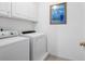 Bright laundry room with a white washer and dryer and a framed picture at 1677 Angelica Ct, Lawrenceville, GA 30043