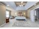 A main bedroom featuring a tray ceiling, ceiling fan, neutral color walls, carpet, and a comfortable seating area at 1677 Angelica Ct, Lawrenceville, GA 30043