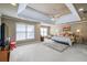 A main bedroom featuring a tray ceiling, ceiling fan, neutral color walls, carpet, and bright light from the window at 1677 Angelica Ct, Lawrenceville, GA 30043