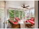 A screened porch that includes comfortable wicker furniture with red cushions, a ceiling fan, and views of the landscape at 1677 Angelica Ct, Lawrenceville, GA 30043