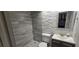 Bathroom featuring walk-in shower, decorative stacked stone wall, updated vanity with tile flooring at 620 Peachtree Ne St # 502, Atlanta, GA 30308