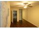 Bedroom with dark wood floors, ceiling fan, mirrored closet doors and view of kitchen at 620 Peachtree Ne St # 502, Atlanta, GA 30308