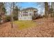 Large back of house with a deck overlooking the yard covered in leaves with mature trees in the background at 1355 Zephyr Ct, Cumming, GA 30041