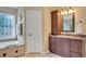 Bathroom featuring a bathtub, vanity with storage, and decorative window at 1355 Zephyr Ct, Cumming, GA 30041