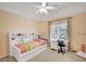 Cozy bedroom featuring built-in shelves, desk area, ceiling fan, and natural light from the window at 1355 Zephyr Ct, Cumming, GA 30041