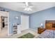 Lovely bedroom has cheerful blue walls, natural light, and a playful vehicle-themed rug at 1355 Zephyr Ct, Cumming, GA 30041