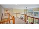 Bright hallway with wood banister overlooking dining area and large arched window allowing for natural light at 1355 Zephyr Ct, Cumming, GA 30041