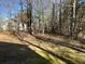 A home with a large backyard featuring mature trees and grass at 225 Whirlwind Ct, Atlanta, GA 30349