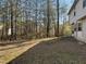 A home with a large backyard featuring mature trees and grass at 225 Whirlwind Ct, Atlanta, GA 30349