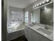 The bathroom has a double sink vanity with a large tub beneath a window at 225 Whirlwind Ct, Atlanta, GA 30349