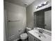 This bathroom features a single sink vanity, toilet, shower and tub with neutral walls and a light fixture at 225 Whirlwind Ct, Atlanta, GA 30349