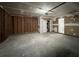 View of the unfinished garage, with exposed framing, garage door and a doorway to interior of home at 225 Whirlwind Ct, Atlanta, GA 30349