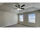 The main bedroom has two windows, carpet, and a ceiling fan with lighting fixture at 225 Whirlwind Ct, Atlanta, GA 30349