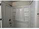 This bathroom features a single shower and tub with built-in shelving and white tiled walls at 225 Whirlwind Ct, Atlanta, GA 30349