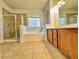 Well-lit bathroom with a separate shower and soaking tub, double vanity, and tile flooring at 3740 Crowchild Dr, Cumming, GA 30041