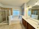 Bright bathroom featuring a soaking tub, glass-enclosed shower, and double vanity at 3740 Crowchild Dr, Cumming, GA 30041