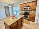 Well-lit kitchen featuring stainless steel appliances, a granite island, and wooden cabinets at 3740 Crowchild Dr, Cumming, GA 30041