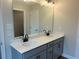 Bathroom featuring double sink vanity with modern fixtures and a large mirror and modern cabinets at 409 Carrera Ln, Acworth, GA 30102