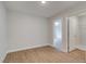 Bright bedroom features light wood floors, neutral walls, and a large closet and doorway leading to the next room at 409 Carrera Ln, Acworth, GA 30102