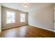 Bedroom features hardwood flooring, neutral walls, white trim, and two windows flooding the room with natural light at 409 Carrera Ln, Acworth, GA 30102