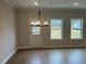 Dining area with hardwood floors, a chandelier, and windows offering natural light and backyard views at 409 Carrera Ln, Acworth, GA 30102