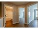 Hallway with wood flooring, neutral walls, and three doorways leading to a bathroom, a bedroom, and another room at 409 Carrera Ln, Acworth, GA 30102