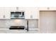 Close-up of a modern kitchen with stainless steel microwave, granite countertops, and stylish backsplash at 409 Carrera Ln, Acworth, GA 30102