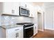 Modern kitchen with stainless steel microwave, white cabinets, granite countertops and stylish herringbone backsplash at 409 Carrera Ln, Acworth, GA 30102