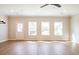 Well-lit living room with wood floors, a white door and ample windows overlooking the backyard at 409 Carrera Ln, Acworth, GA 30102