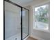 Modern glass shower features a window, allowing natural light, enhancing the elegant bathroom space at 409 Carrera Ln, Acworth, GA 30102