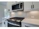 Close-up of a kitchen featuring gas range and stainless-steel microwave and white quartz countertop at 420 Carrera Ln, Acworth, GA 30102