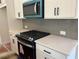 Modern kitchen featuring white cabinets, grey backsplash, stainless steel appliances, and light countertops at 420 Carrera Ln, Acworth, GA 30102