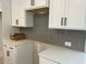 Close up of kitchen with white cabinets, grey backsplash, modern pulls, and light countertops at 420 Carrera Ln, Acworth, GA 30102