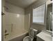 Bathroom featuring a white vanity with a sink, a window, and a tub-shower combo with white tile surround at 47 Brushy Mountain Way, Rockmart, GA 30153