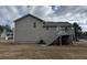 Home exterior features gray siding, a rear staircase to a deck, and a spacious yard, blending comfort with outdoor living at 47 Brushy Mountain Way, Rockmart, GA 30153