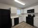 Modern kitchen featuring white cabinets, black appliances, and new countertops at 47 Brushy Mountain Way, Rockmart, GA 30153