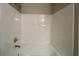 A tub and shower combination featuring white tile, chrome fixtures and freshly painted neutral-colored walls at 4735 Jackam Ridge Ct, Lithonia, GA 30038